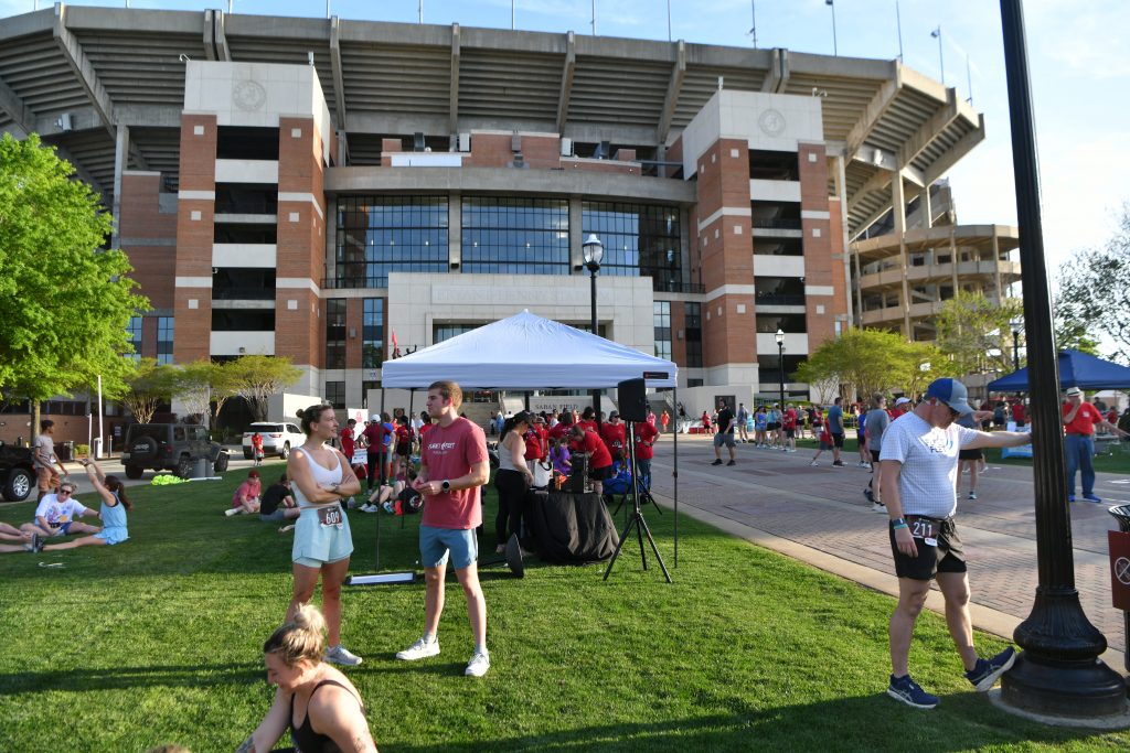 Runners and walkers talking and stretching outside Bryant-Denny stadium