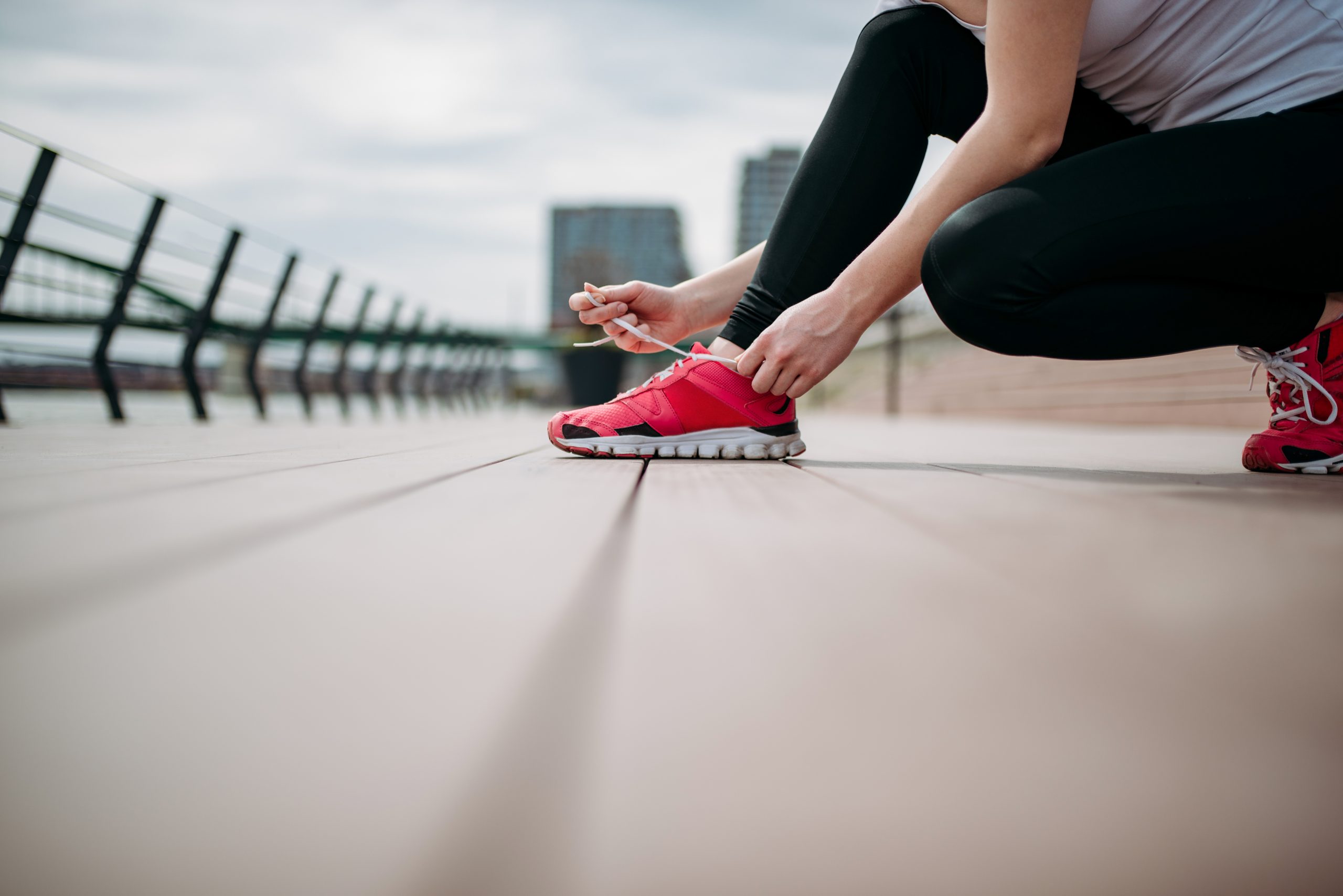 Low angle photo of female athlete tying shoe lace.