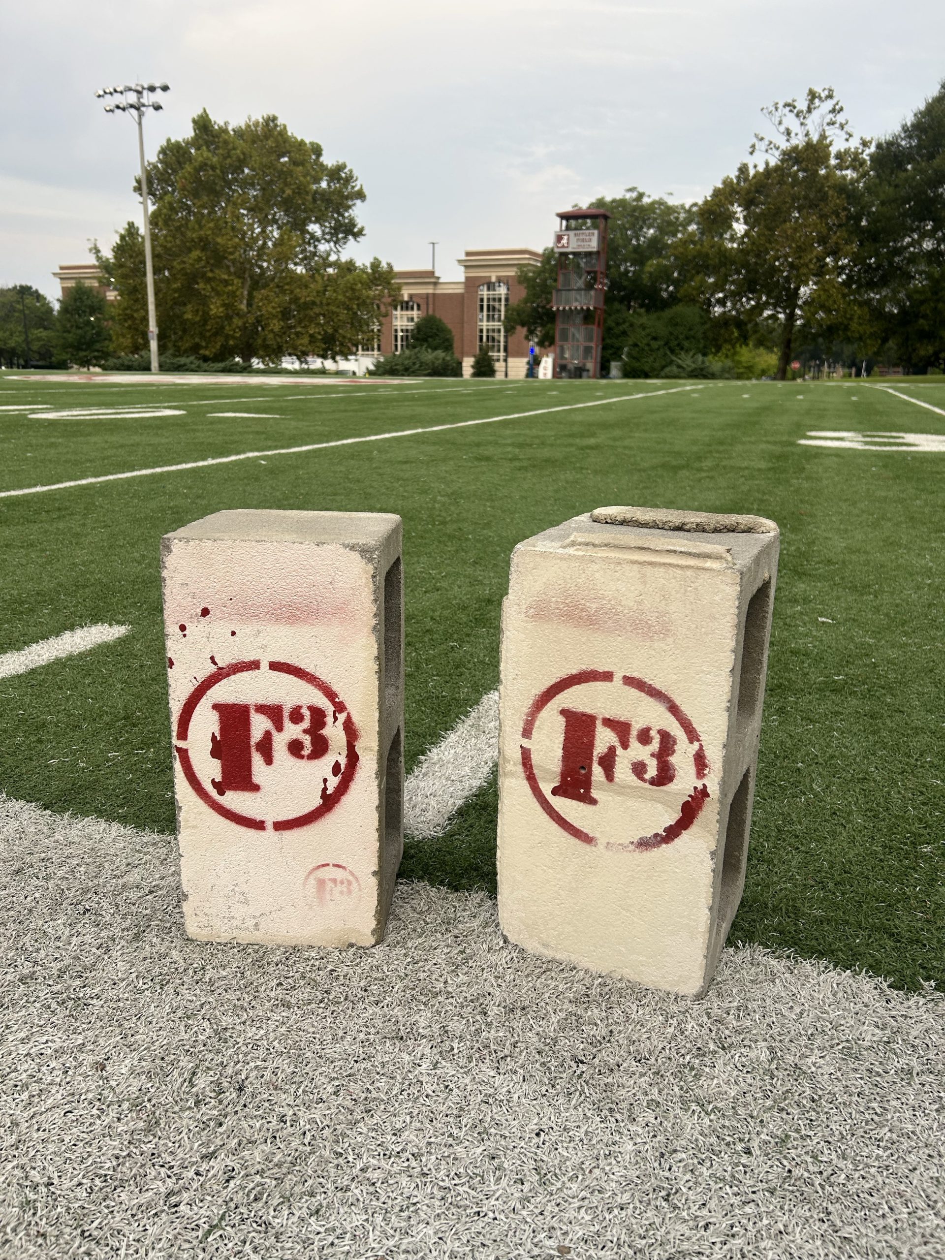 3 cinderblocks painted with F3 logo on a turf field