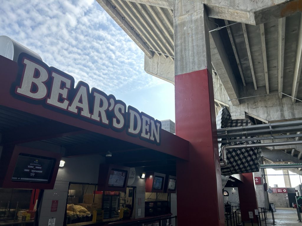 concession stand under the stadium awning with Bear's Den sign on top.