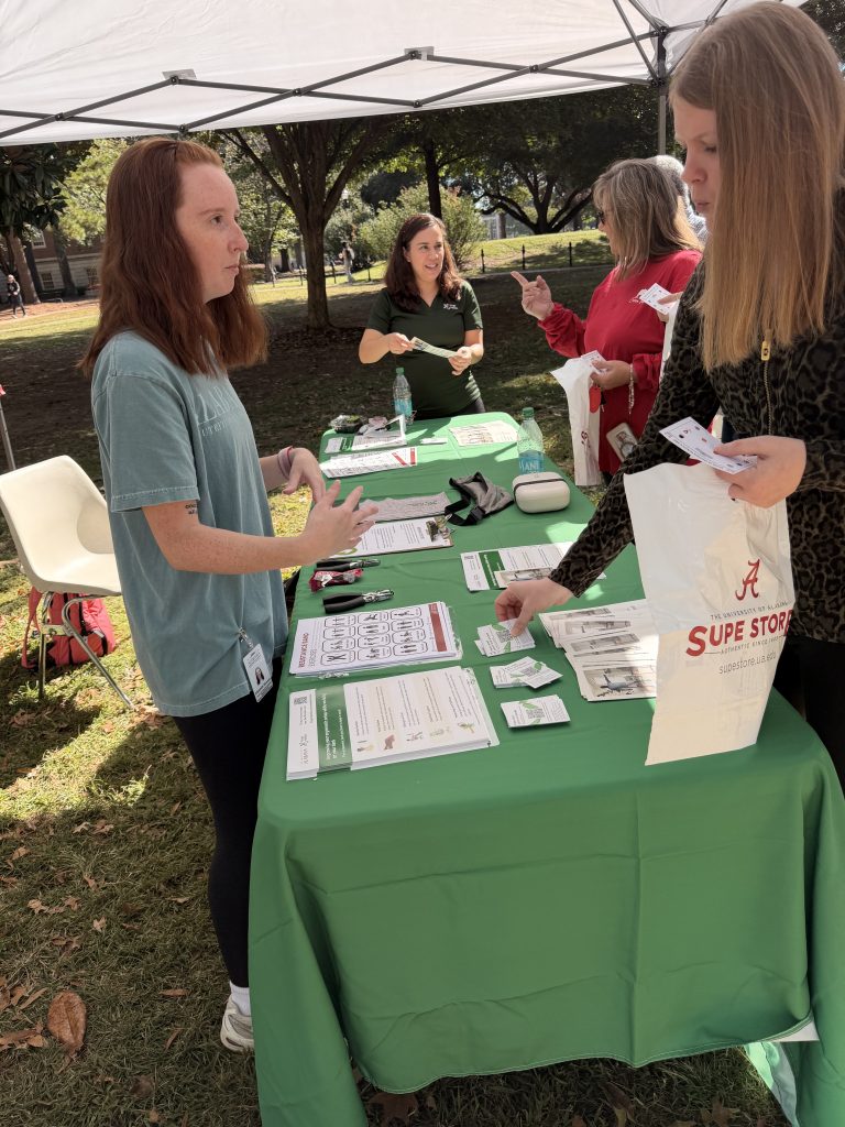 4 women discuss workplace posture and hinge health while giving away handouts and information on the app